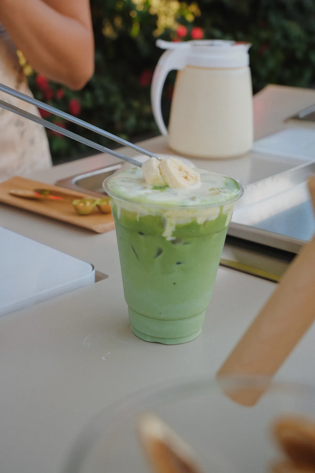 Banana pie iced matcha being finished with toppings